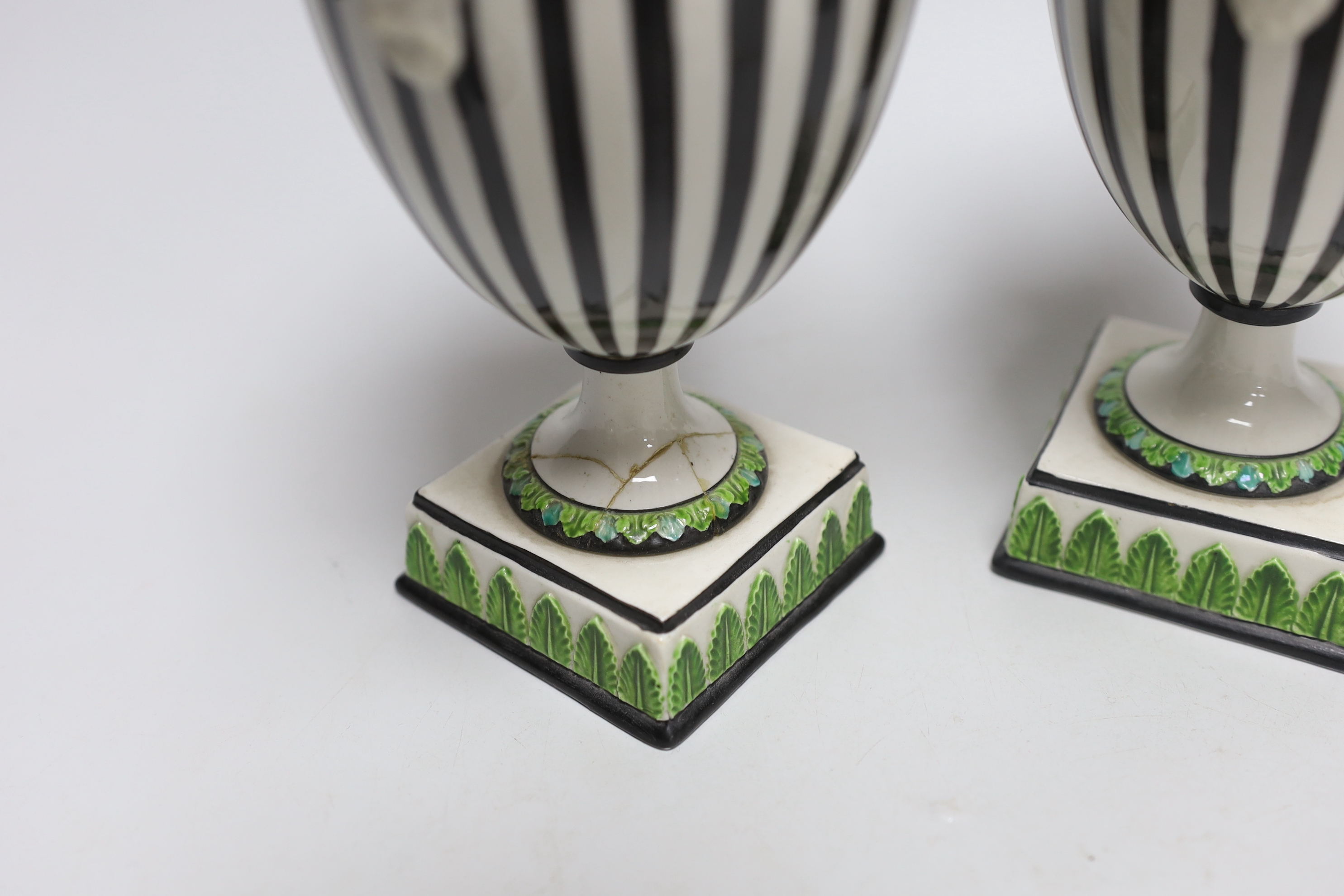 A pair of Wedgwood urns with twin handles and acorn design knops, each 22cm high